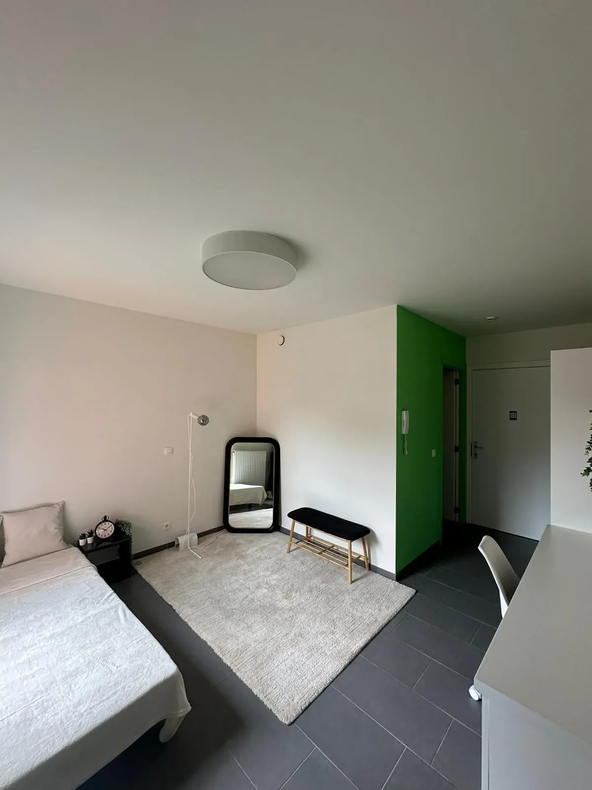 Studentenkamer met eenpersoonsbed, passpiegel en zithoek