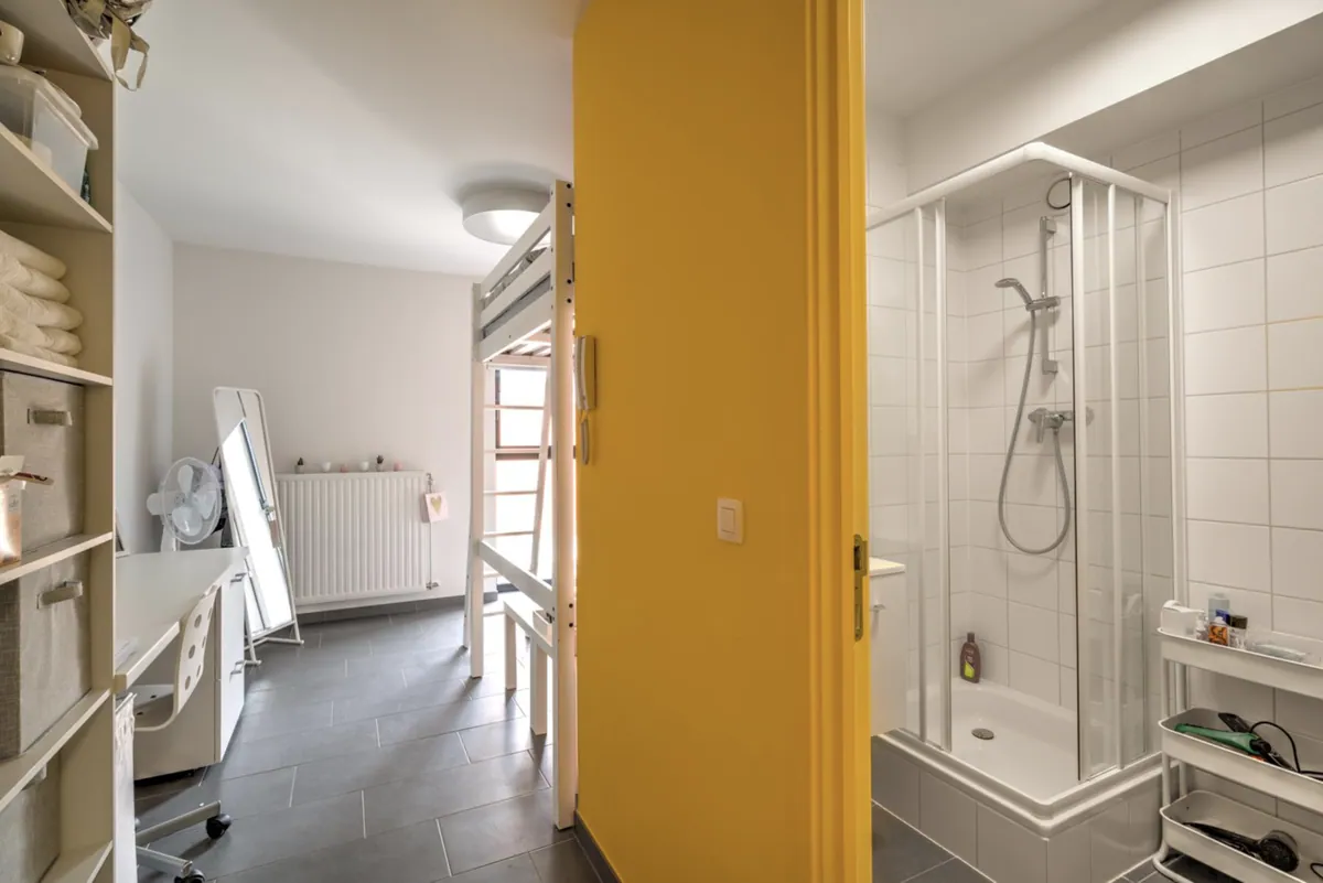 Studentenkamer met doorkijk naar de eigen badkamer met douche